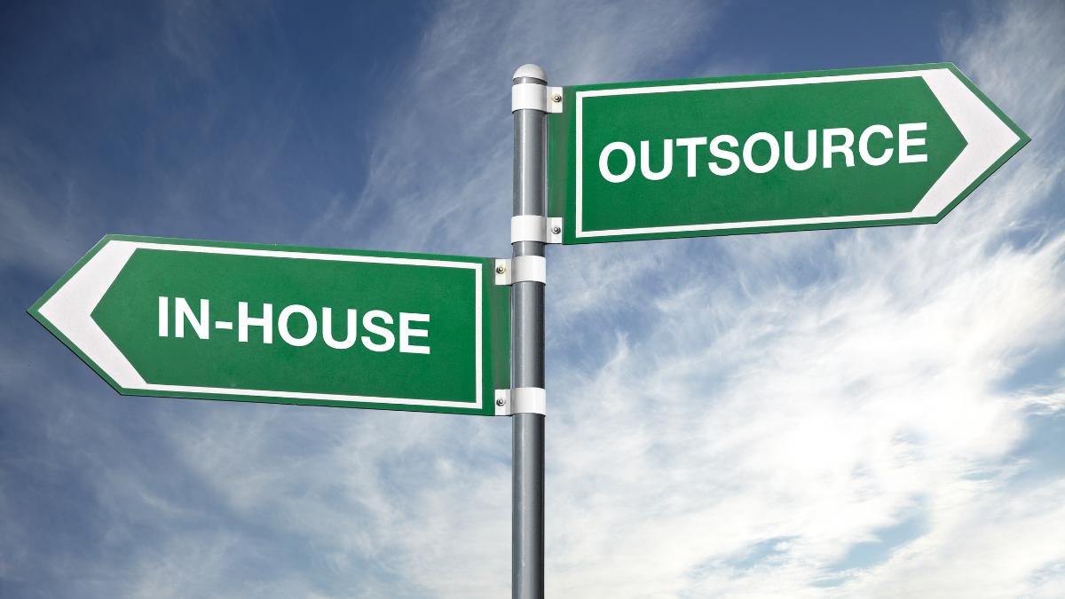 Signpost pointing in two directions: "IN-HOUSE" and "OUTSOURCE"